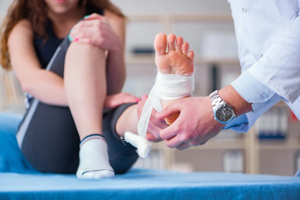 woman with a sports injury on her foot getting it wrapped and evaluated for the best physical therapy treatment needed